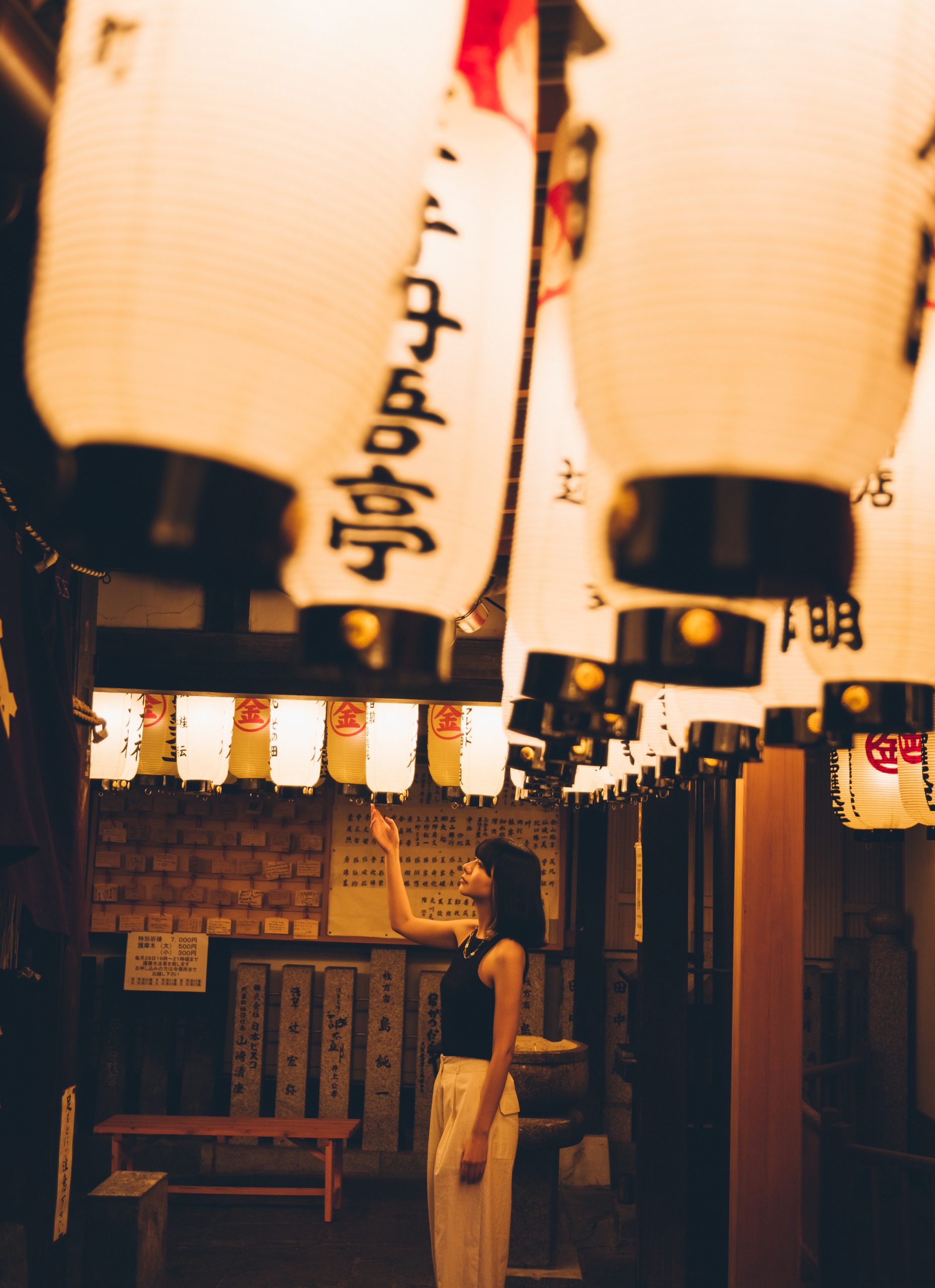Woman standing beneath paper lanterns