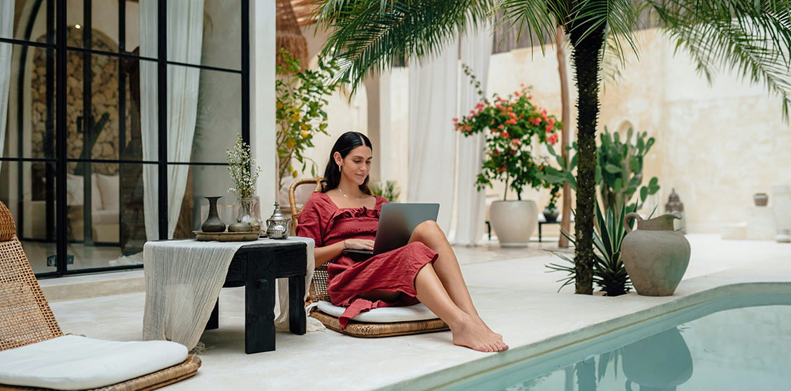 woman by pool on laptop