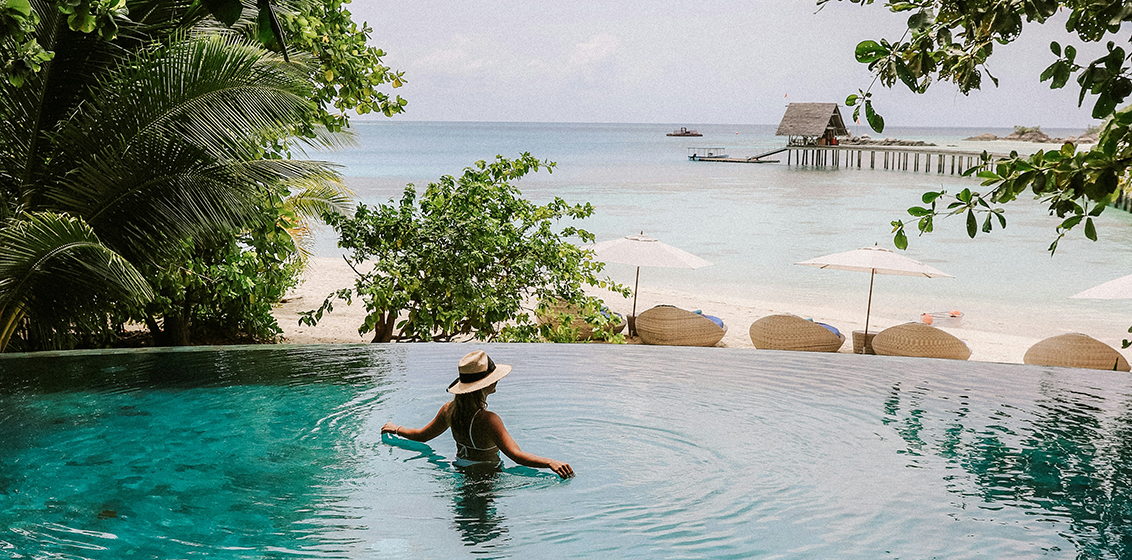 woman in pool by ocean